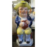 A Staffordshire toby jug, of a seated man holding a jug of ale, height 10ins