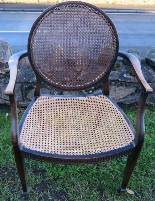 A cane and mahogany open arm chair