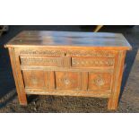 An antique oak coffer, with rising lid and carved front, width 50ins x depth 21ins x height 31.5ins