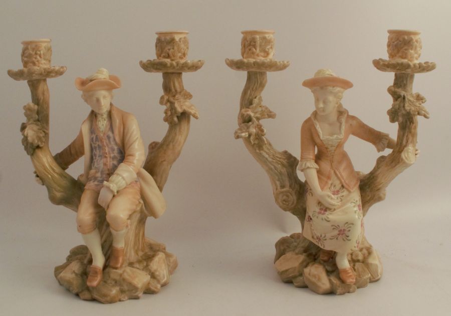 A pair of Royal Worcester blush ivory candelabra, formed as seated figures in the fork of branches