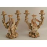 A pair of Royal Worcester blush ivory candelabra, formed as seated figures in the fork of branches