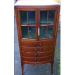 A mahogany bow front cabinet, having a pair of glazed doors over four music drawers, 20.5ins x 16.