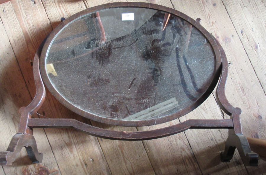 An oval mahogany framed dressing table mirror