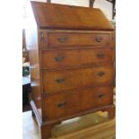 A reproduction mahogany bureau, with fall flap opening to reveal drawers and pigeon holes, over long