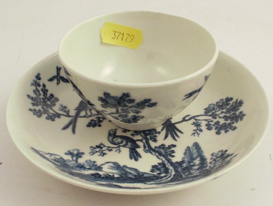 A first period Worcester tea bowl and saucer, decorated in the Birds in Branches pattern, crescent