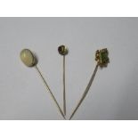 A peridot and diamond stickpin, together with two other stone set stickpins