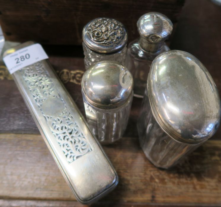 A collection of dressing table bottles, with silver tops
