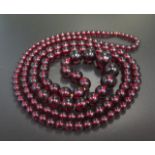 A Faux Red Amber Graduated Bead Necklace, c. 122cm long, largest bead c. 17mm, 62.5g