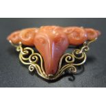 A 19th Century Carved Coral Ram's Head Brooch in an unmarked gold setting, 37mm diam. 5.2g