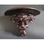 A Carved Lion Mask Wall Shelf, 26cm wide