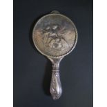 A Victorian Silver Backed Hand Mirror decorated with a scene of a seated woman with putti in a