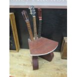A Unique Guitar Chair, the base formed from two guitar bodies and the back by three necks. According