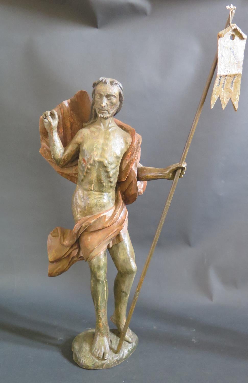 An 18th Century or Earlier Continental Carved Ecclesiastical Figure holding a staff with banner,