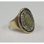 A Georgian Diamond and Enamel Memorial Ring set with platted hair and in an unmarked gold setting,