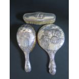 A Birmingham Silver Backed Hand Mirror and Brushes decorated with Cupids, matched