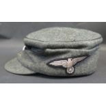 A German WWII Army Field Cap with SS Totenkopf Skull badge and eagle cloth badge to side, inside