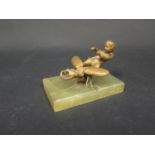 A Bronze Model of Cupid Riding a Beetle and on an onyx base, 10cm base.Three legs missing