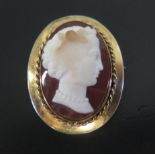 A Carved Hardstone Cameo Brooch decorated with a female bust and in an unmarked gold setting,