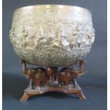 A Large Burmese Silver Thabeik Bowl decorated figures in various poses with foliate scroll borders