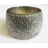 A Victorian Silver Hinged Bangle embossed with floral decoration, 49mm wide, two dents to body, 99g