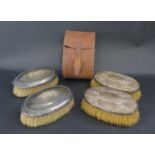 A Pair of Leather Cased Silver Backed Brushes and one other pair of silver backed brushes