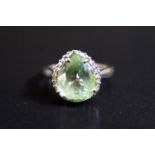 An 18ct White Gold Ring set with Pale Green Pear Cut Stone and Diamond Surround, size N, 3.6g