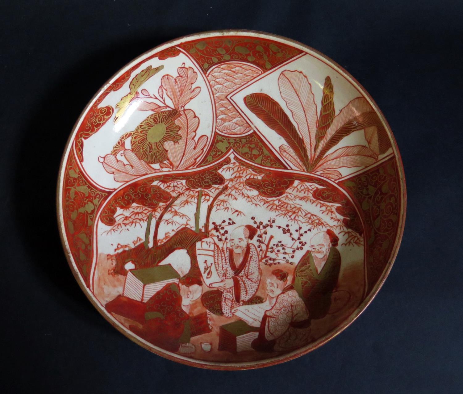 A 19th Century Japanese Earthenware Shallow Dish decorated in iron oxide and gilt with seated