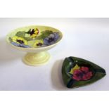 A W. Moorcroft Pansy Decorated Footed Bowl (18cm diam.) and ashtray, both with Queen Mary stickers