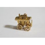 A 9ct Gold Gypsy Caravan Charm with hinged top and articulated wheels, 5g