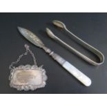 A Silver WHISKY Label, silver and mother of pearl handled butter knife and silver sugar tongs, 37g