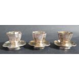 A Set of Three Chinese Silver Cups and saucers with chased foliate decoration, 7cm diam., 158g