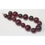 An 11.5" Faux Cherry Amber Bead Strand, largest 21x19mm, 64.9g