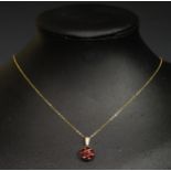 A 9ct yellow Gold and Seven Stone Garnet Cluster Pendant (20mm drop, 1.3g) and on a 9ct gold