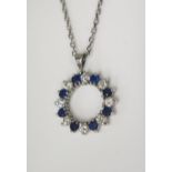 An 18ct White Gold, Sapphire and Diamond Circle Pendant set with sixteen alternating stones (7mm