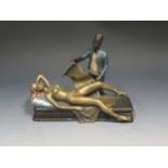 A Cold Painted 'Orientalist' Bronze of a reclining lady with hinged skirt and man in fez, 18.5cm