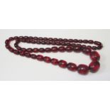 A 35.5" Faux Cherry Amber Graduated Bead Necklace, largest 27x22mm, 100.9g