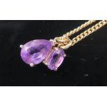 A 9K Yellow Gold and Amethyst Pendant (c. 13mm drop) and one smaller on a gilt chain