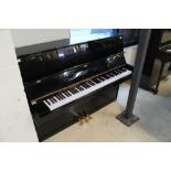 Carlmann (c2000) An upright piano in a modern style bright ebonised case.