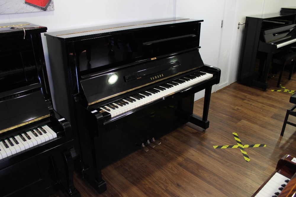 Yamaha (c1976) A Model U1 upright piano in a bright ebonised case.