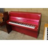Wilh. Steinmann (c1980s) A small modern style upright piano in a dark metallic pink case.