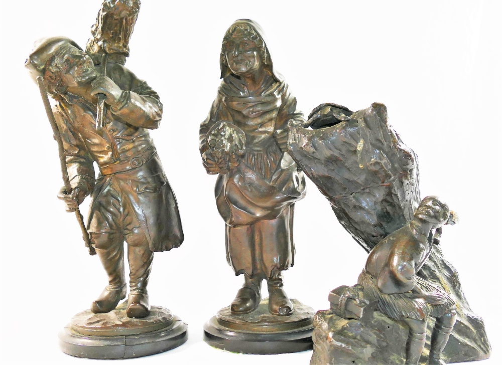 A pair of bronze figures of elderly peasants carrying bundles of sticks, on circular marble base,