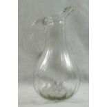 An 18th century French glass jug with moulded vertical ribs and folded rim,
