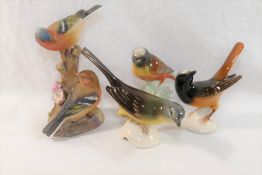 A collection of ceramic bird figures and groups including a Royal Worcester porcelain bird group