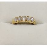 A yellow metal diamond five stone ring, the five round brilliant cut stones each approximately 0.