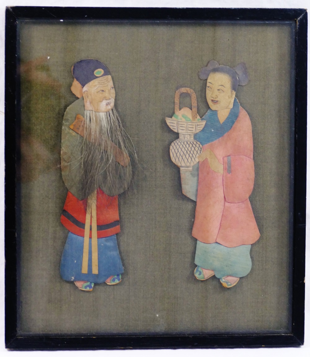 An early 20th century Chinese fabric covered panel mounted in relief with a pair of painted fabric,