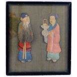 An early 20th century Chinese fabric covered panel mounted in relief with a pair of painted fabric,