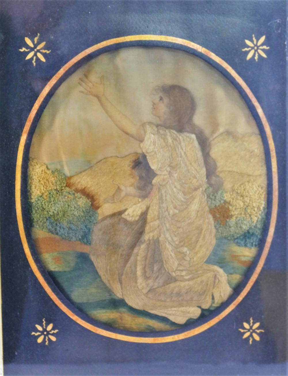 A 19th century oval embroidered silk picture of a young woman kneeling with her arms aloft, - Image 2 of 2