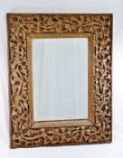 An early 20th century Anglo Indian wall mirror with intricately carved wooden frame,