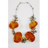 A modern silver coloured metal and large amber bead necklace,
