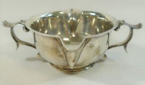 An Arts and Crafts silver two handled and double spouted porringer style bowl,